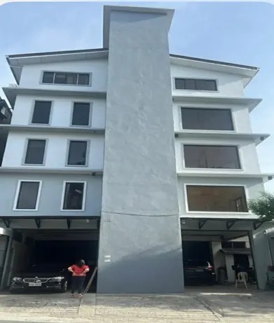 The HUBREES front office building — a four-storey white and grey facade with covered parking at street level